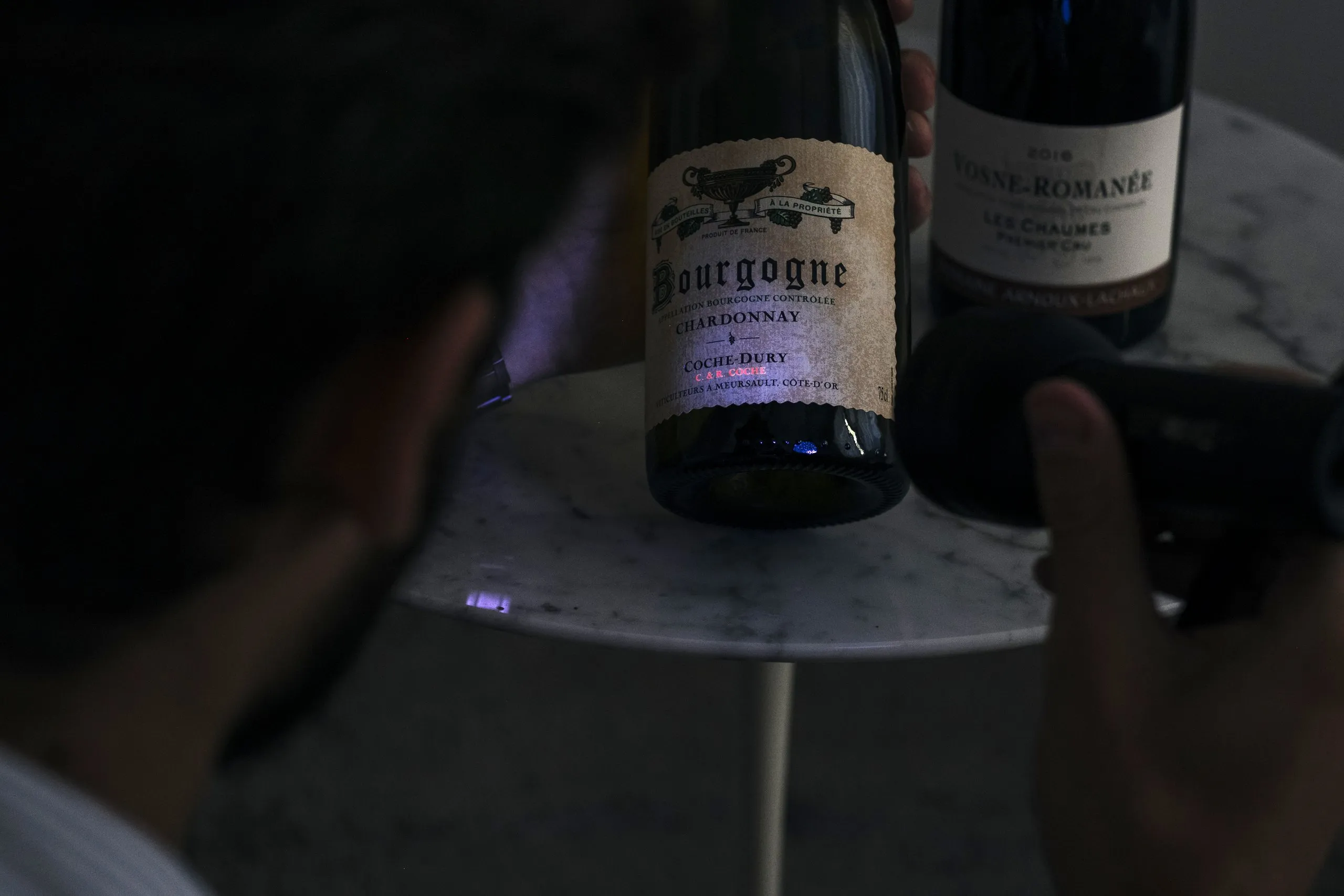 A bottle of Coche-Dury Bourgogne Chardonnay beside a Vosne-Romanée